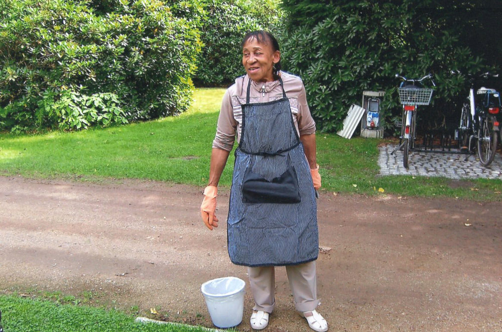 Fraue mit Schürze und Eimer im Garten